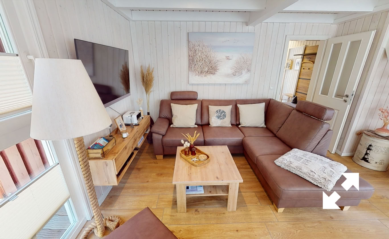 Wohnzimmer mit braunem Ecksofa, Holztisch, Stehlampe, Wandfernseher, Sideboard und Wandbild.